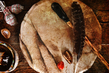 A top view image of a handmade leather meditation drum with sage smudge sticks and healing...