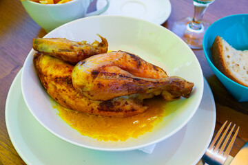 Appetizing baked chicken half with sauce. Swiss cuisine
