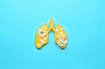 Paper lungs with fresh flowers on blue background