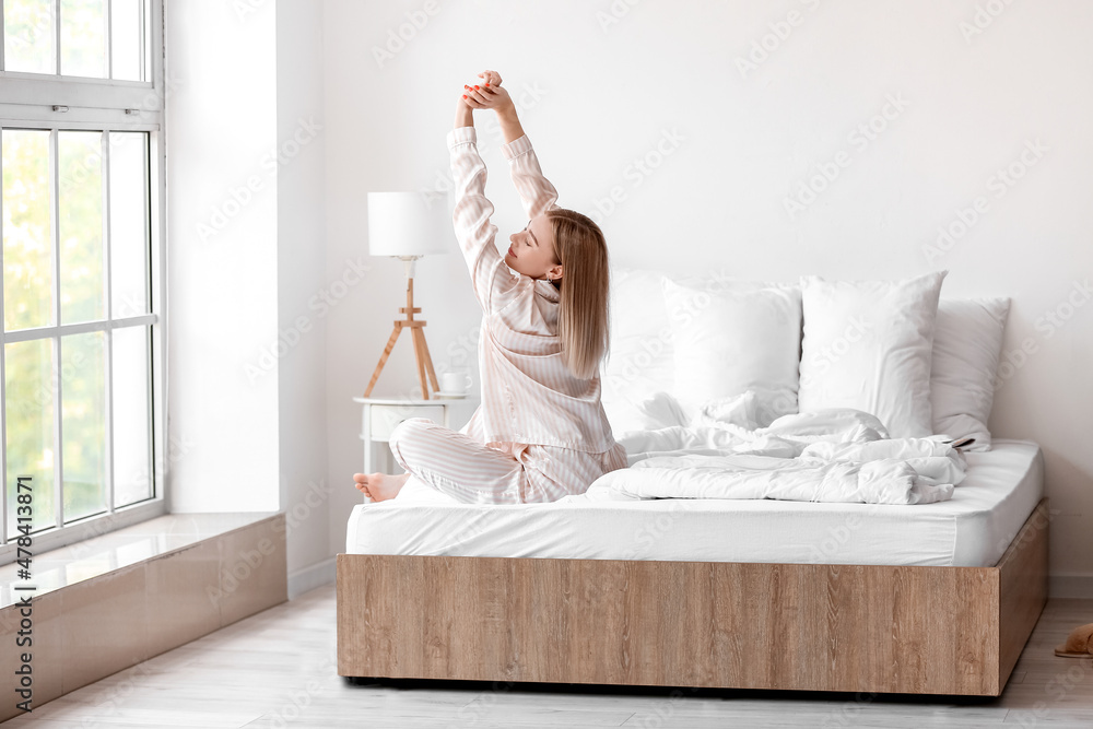 Wall mural morning of beautiful woman stretching on bed