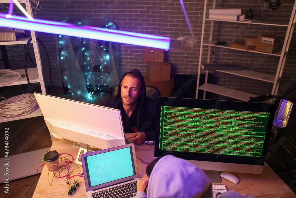 Poster hackers in dark room with computers