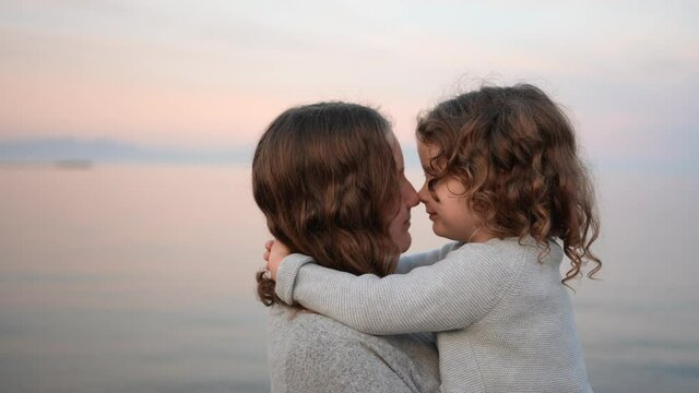  Cute happy siblings hugging each other feeling love and connection, smiling girl hugging little sister on the beach, 2 kids good relations