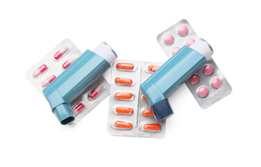 Modern asthma inhalers and blister packs of pills on white background