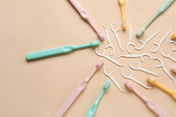 Floss toothpicks and tooth brushes on beige background
