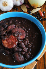 Feijoada top view, brazilian cuisine with garlic, black beans, onion, bay leaves.