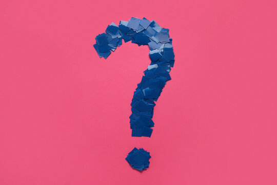 Question Mark Made Of Blue Confetti On Pink Background