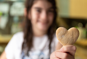Suite girl holding a heart cookie