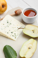 Board with honey, cheese and fruits on table, closeup