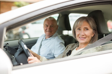 Mature couple sitting in car. Woman sitting at driver's seat.