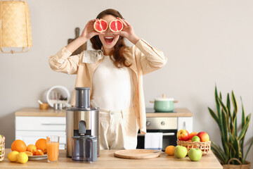 Happy woman preparing healthy fruit juice in kitchen