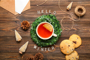 Composition with cup of tea, cookies and decor on wooden background. Hello winter