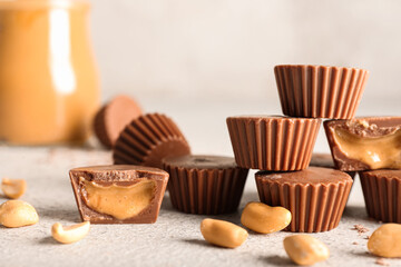 Tasty peanut butter cups on light background