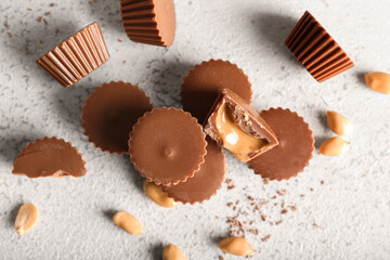 Tasty peanut butter cups on light background
