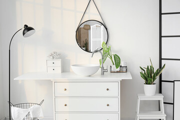 Interior of light bathroom with sink, mirror and standing lamp