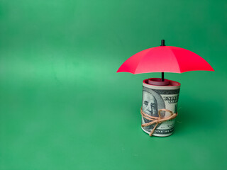 Fototapeta na wymiar Copy and text space.Red umbrellas protect the banknotes, save families, prevent risk and the concept of insurance.
