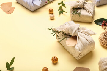 Beautiful gift boxes wrapped in fabric on color background