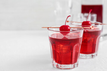 Glasses of delicious Manhattan cocktail on light background, closeup