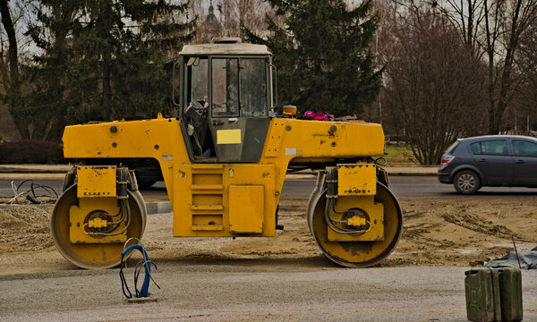Budowa drogi i chodnik&oacute;w . Droga chodnik . Wielki ż&oacute;łty wibracyjny walec drogowy . Costruzione di strade e marciapiedi. Strada, marciapiede. Rullo compressore vibrante giallo grande. 