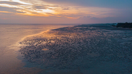 Aerial drone shot of seascape against the sky during golden hour at Sekinchan, Selangor, Malaysia.