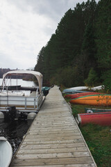 Fototapeta premium Boat dock by the lake with canoes on the lake bank