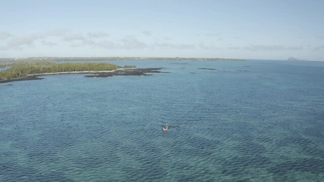Aerial view of a motorboat sailing along the coast at l'Ilot Bernache, a small island along the coast near the reef, Mauritius.