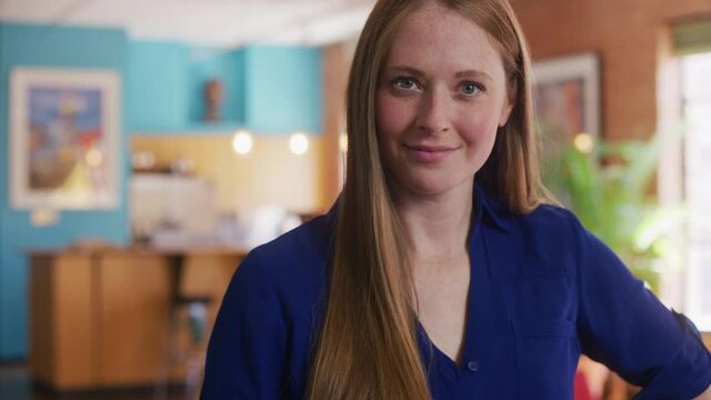Tight shot of a young redheaded Caucasian woman looking at the camera with confidence