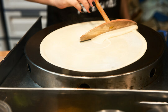 Prepare sweet crepes batter with wood, on white isolated.