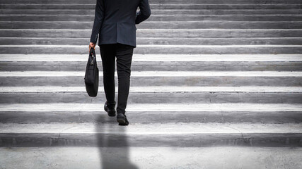 Businessman walking up on staircase. Challenging and motivation concept