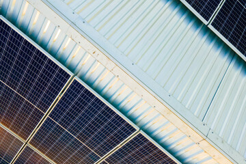 Aerial view of surface of blue photovoltaic solar panels mounted on building roof for producing...