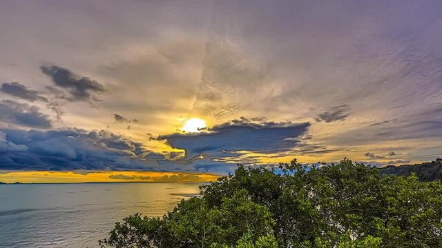 beautiful sunset hidden under clouds over the sea in Guernsey island, Channel Islands, coast of Normandy. Timelapse