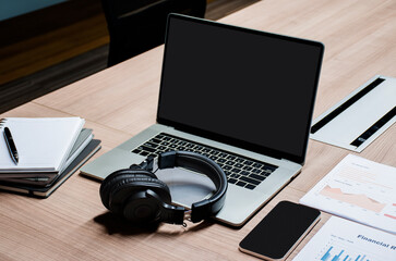 Obraz na płótnie Canvas Laptop blank screen ,headphone and paperwork on table