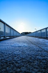 雪の降った早朝の凍った橋の滑りやすい歩道