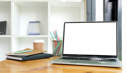 Computer laptop, cactus, pencil holder and books on wooden table..