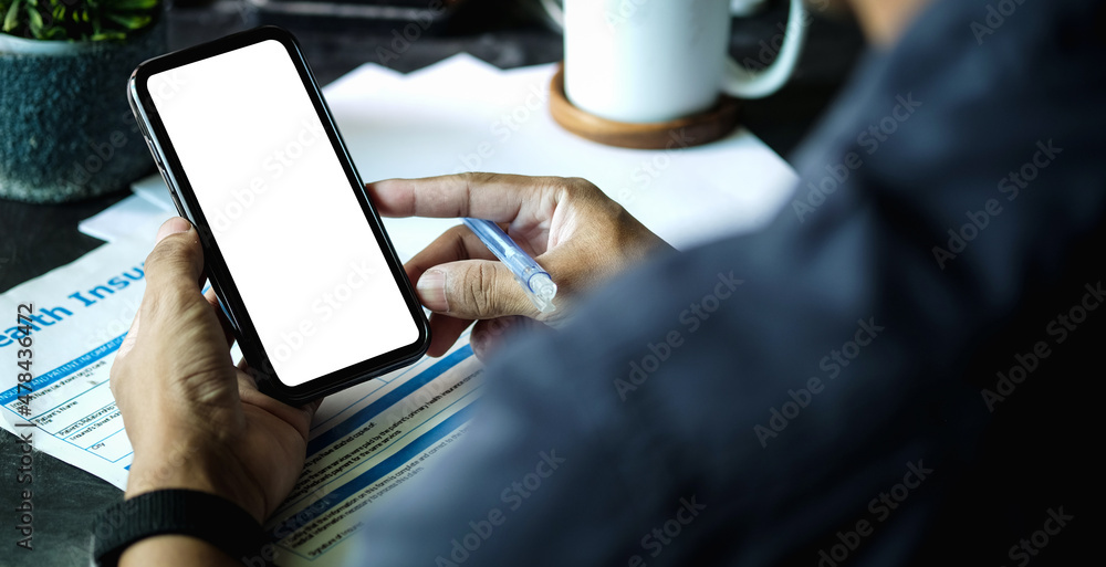 Poster close up view of businessman holding mock up smart phone with blank screen...