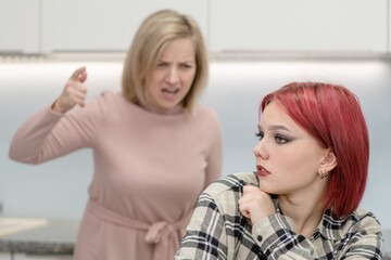 Family conflict. Angry mother screams at scared daughter