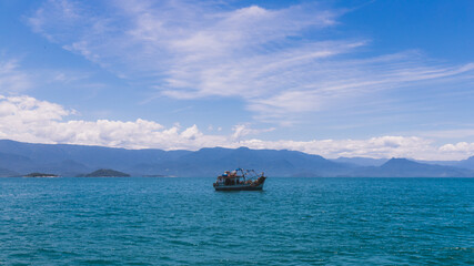 Lonely boat in the blue sea under blue sky