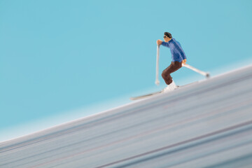 Miniature skier on creative white paper