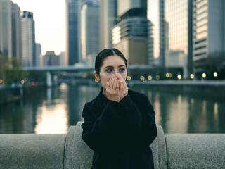 街で手を口に当てる女性