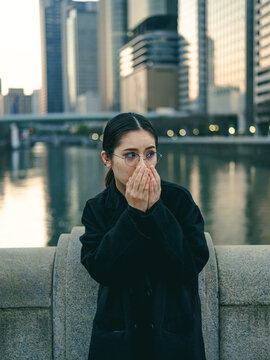 街で手を口に当てる女性