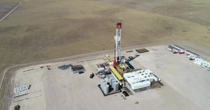 A three hundred foot half orbit of a large drilling operation revealing another rig in the same field.  drone 4K 60fps