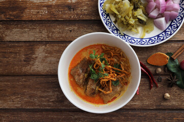 Local northern Thai food Egg noodle curry with pork ribs on wood background