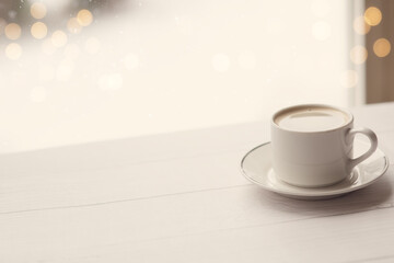 cup of coffee on table with bokeh on the background