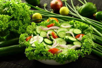Fresh green cucumber salad, garnished with tomatoes, onions,herbs.