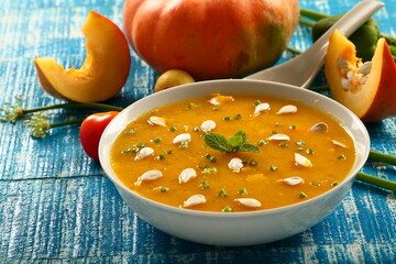 Healthy vegan diet meal- bowl of delicious organic pumpkin soup garnished with pumpkin seeds.