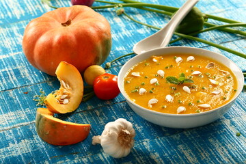 Healthy vegan diet meal- bowl of delicious organic pumpkin soup garnished with pumpkin seeds.
