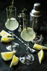 Lemon  liquor (limoncello) on dark  background and ripe juicy lemon