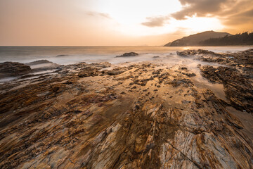 waves and rocks in sunrise in long exposure