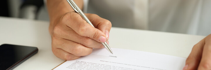 Woman signs contract for purchase of car on credit closeup