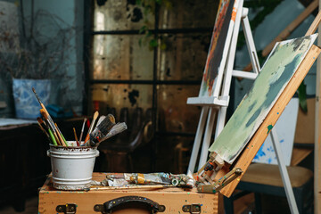 Creative background on canvas, working in real studio with oil paints and brushes, picture of modern art. over the window, candlelight. Workspace of artist