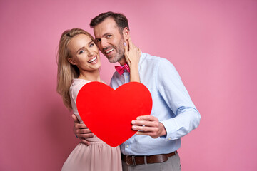 Caucasian ethnicity mature couple holding a red heart